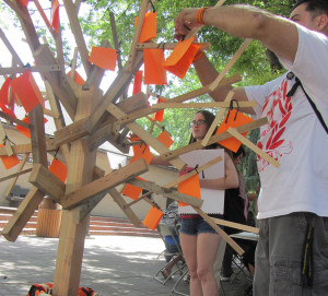 MEMORY TREE: Robert Duran hangs a note on the memory tree in the quad on Tuesday, April 30.