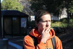 NO BUTTS ALLOWED: Delta student Chris Staggs enjoys a cigarette in the Shima 1 parking lot on Feb. 5. Behind him, the smoking ban sign looms.